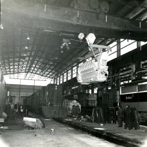 View is north to south of the interior of the new car shop with an Alco engine hanging on the bridge crane. NH 0464, 0785, 1228 - DER-3a, DERS-4