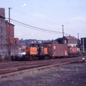 Distant photo of GE 44-tonner #0807 at Providence eastbound hump yard, Providence, RI.  Also in photo is unidentified S-1, NYC boxcar is between 0807 and the S-1