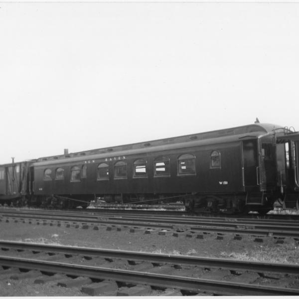 Work Train Dining Car W-153, Formerly Dining Car #2312, In tool train. Side View. Work Service Boxcars, with white script heralds and windows Cut into their doors, visible to the left of the diner. Entire tool train looks freshly painted.