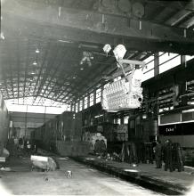 View is north to south of the interior of the new car shop with an Alco engine hanging on the bridge crane. NH 0464, 0785, 1228 - DER-3a, DERS-4