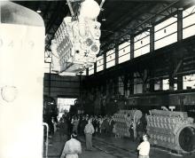 View is from the north to the south of the interior of the new car shop during a crane hoisting demonstration.