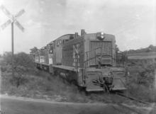 Four SW-1200s approaching level crossing
