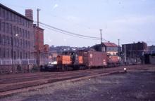 Distant photo of GE 44-tonner #0807 at Providence eastbound hump yard, Providence, RI.  Also in photo is unidentified S-1, NYC boxcar is between 0807 and the S-1